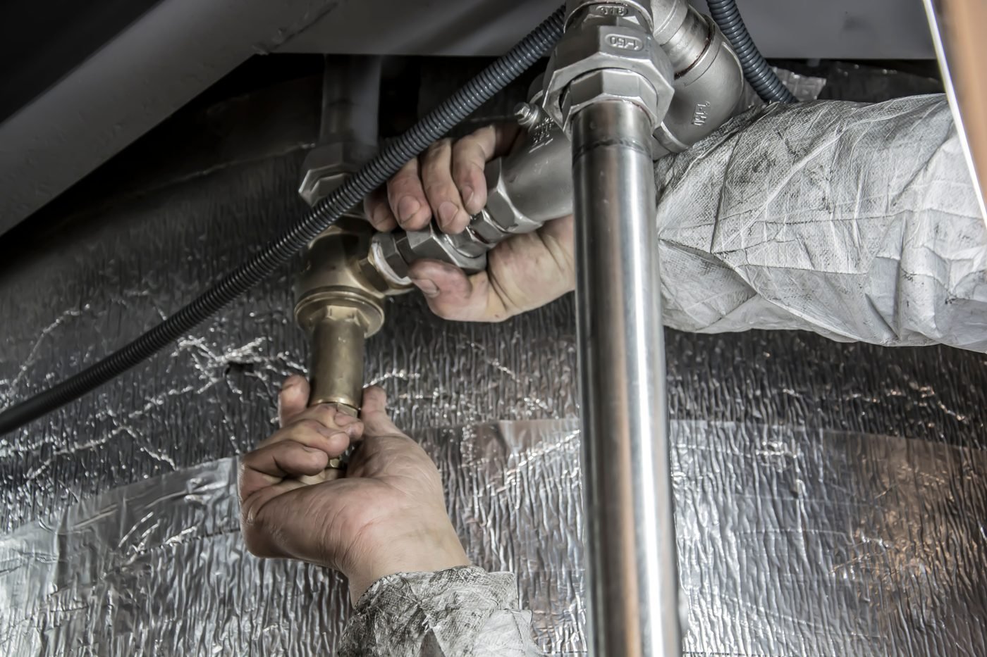 A plumber making an emergency pipe repair in a York, PA home — Scott's H Plumbing, dispatched 24 hours